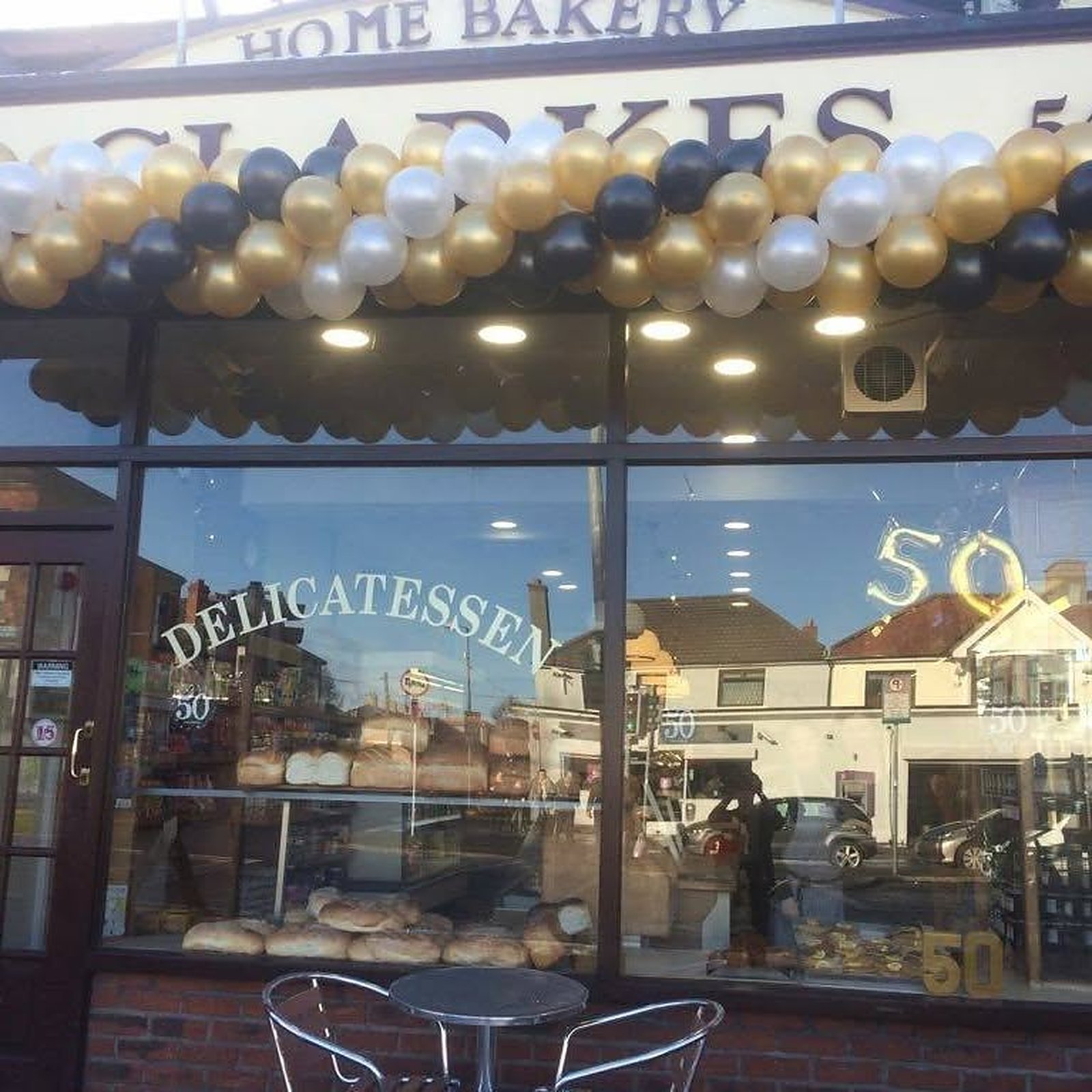 Clarke's Home Bakery shopfront on New Cabra Road, decorated with a gold, black and white balloon arch and a number 50 in the window.